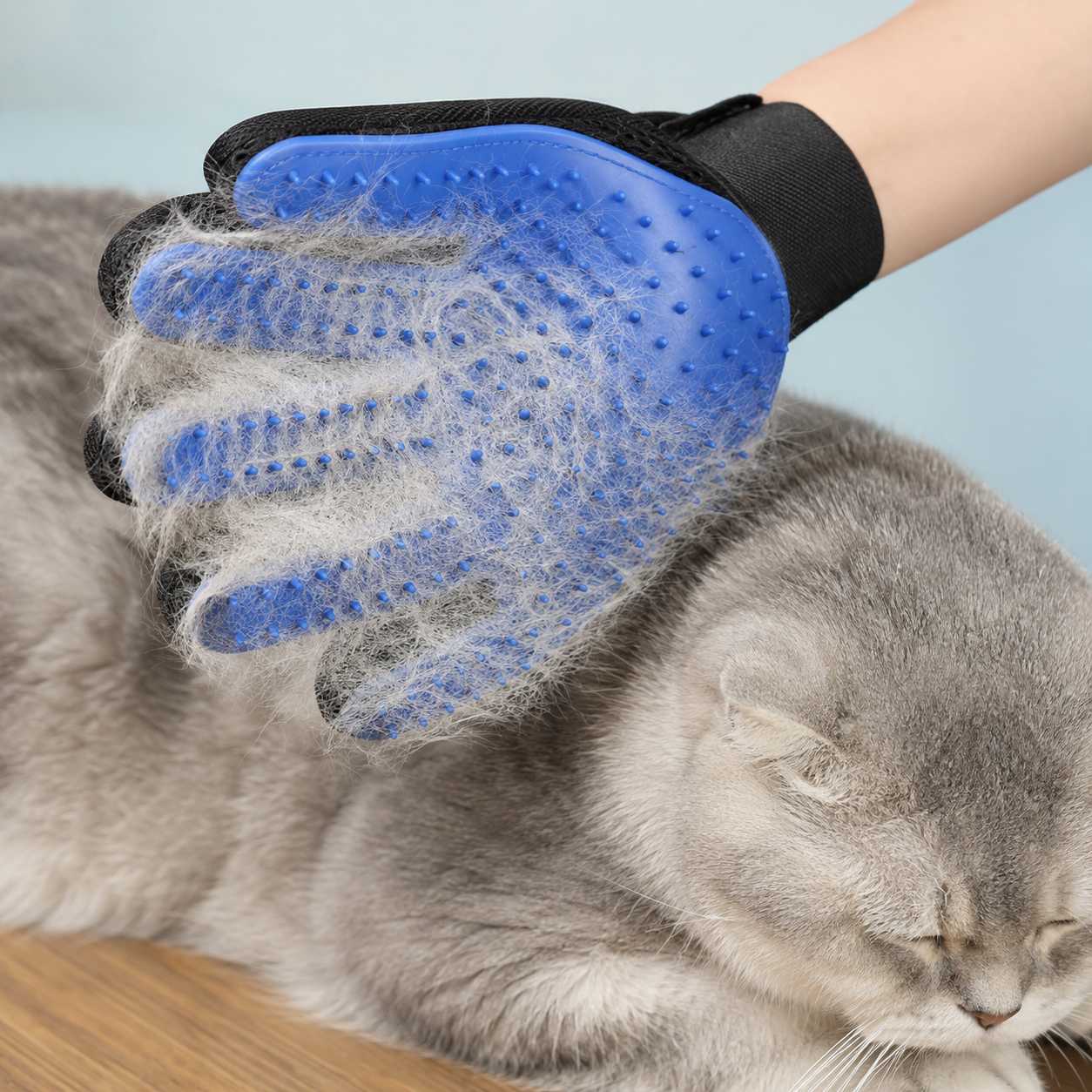 Blue silicone dog and cat grooming glove with adjustable wrist strap
